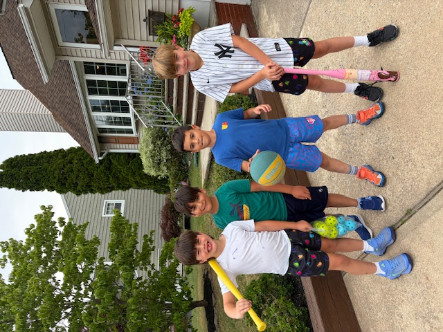 Small group of kids with baseball bats and ball