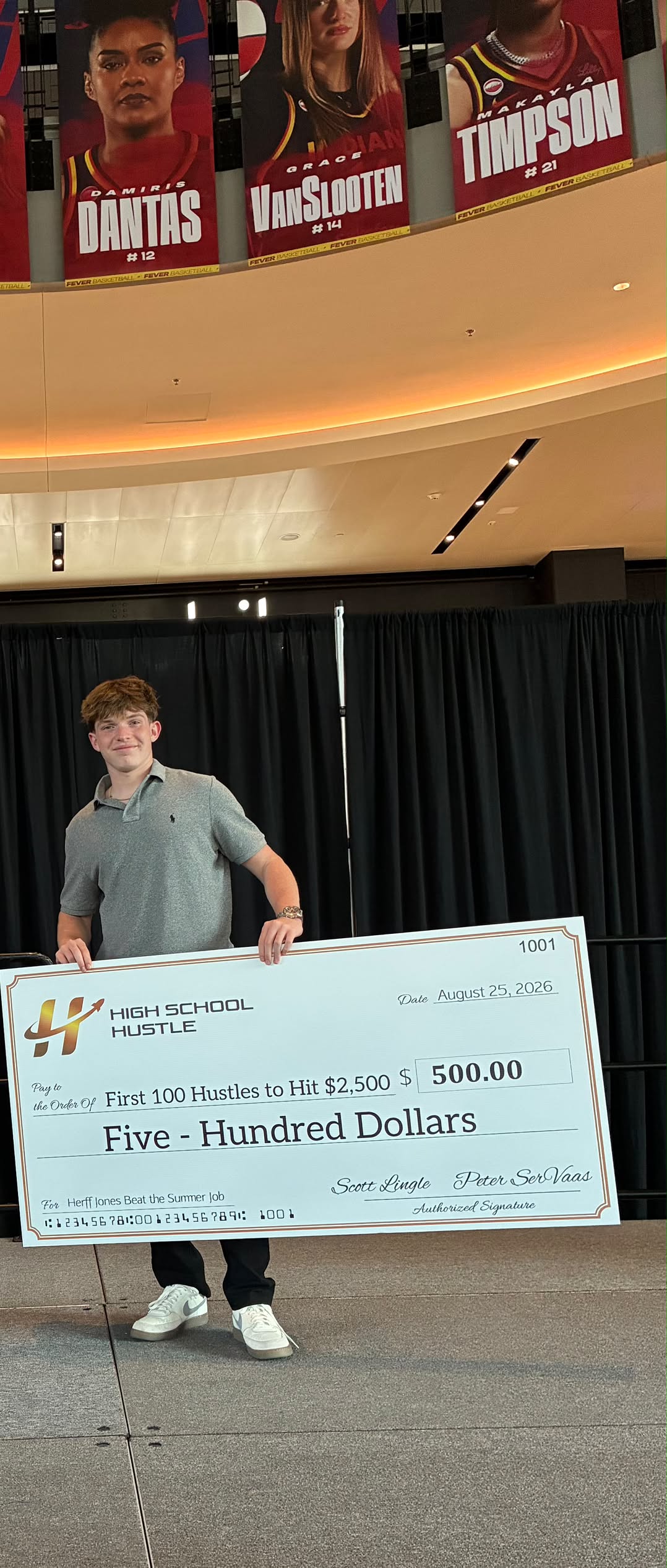 Cody DeCoons holding his $500 High School Hustle award check