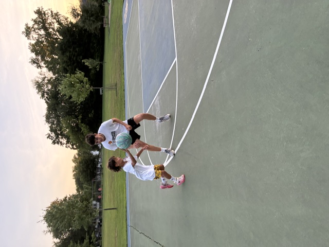 Sports Sitter playing one-on-one basketball with a young athlete