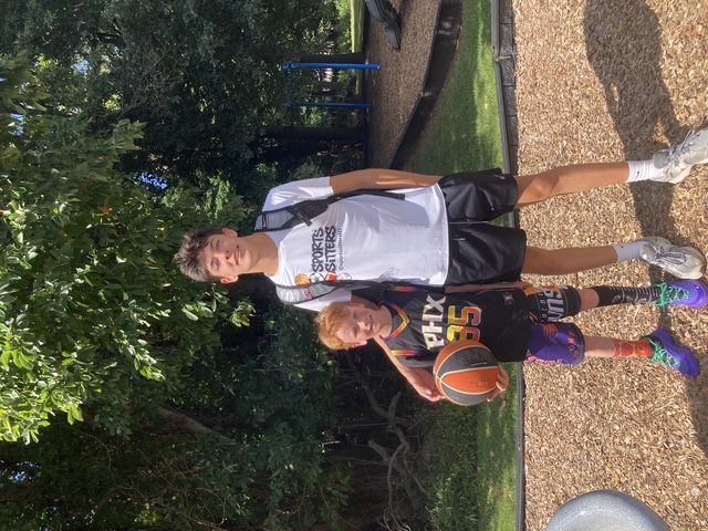 Sports Sitter and young athlete posing with a basketball
