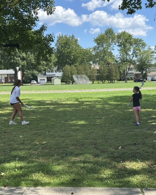 Sports Sitter running a lacrosse drill at the park