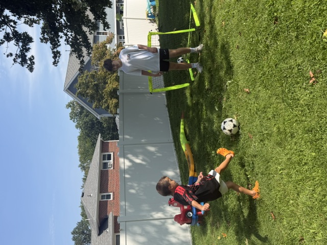 Sports Sitter running a soccer drill in the backyard