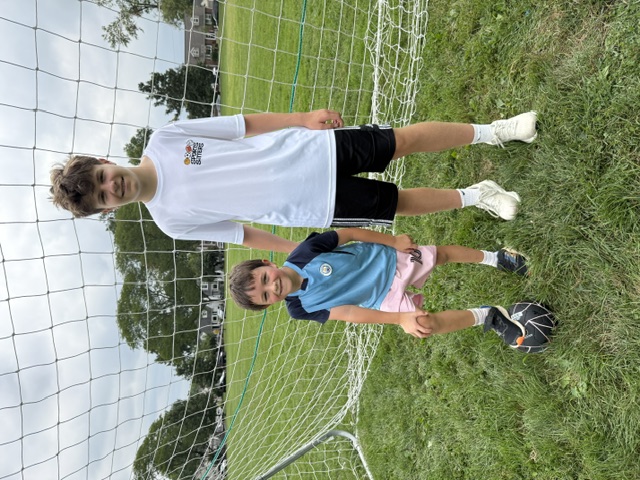 Sports Sitter posing with young athlete and soccer ball